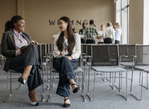 2 Women Sitting in Office Chairs